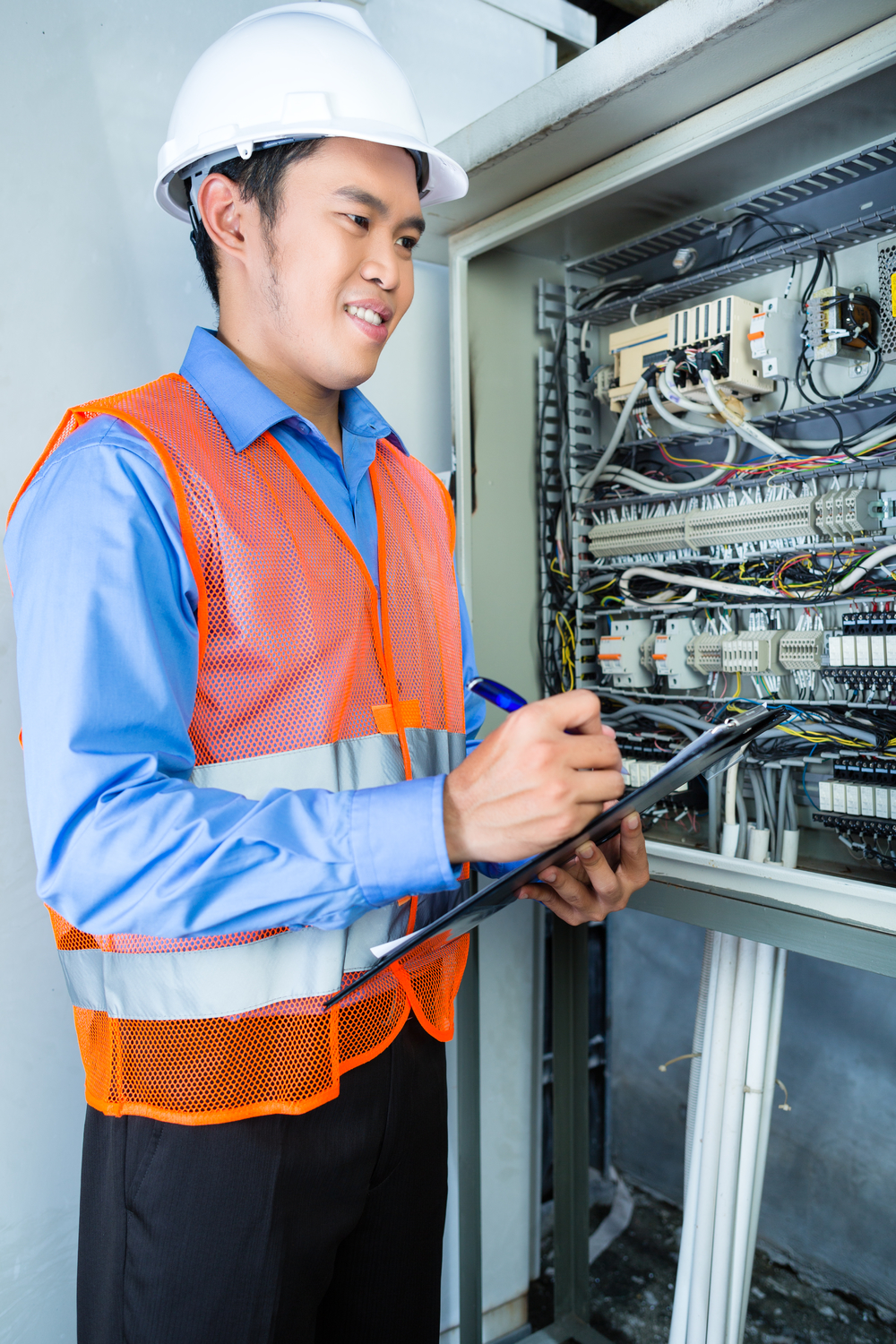 印尼亚裔技术员或电工在施工现场或工厂对带电源线的断路器箱或开关箱进行功能测试以进行验收